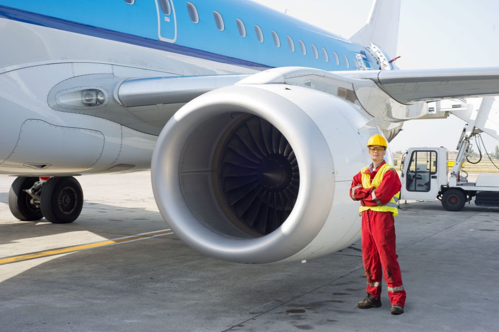 15045016 - jet engine mechanic posing next to a commercial aircraft on the runway